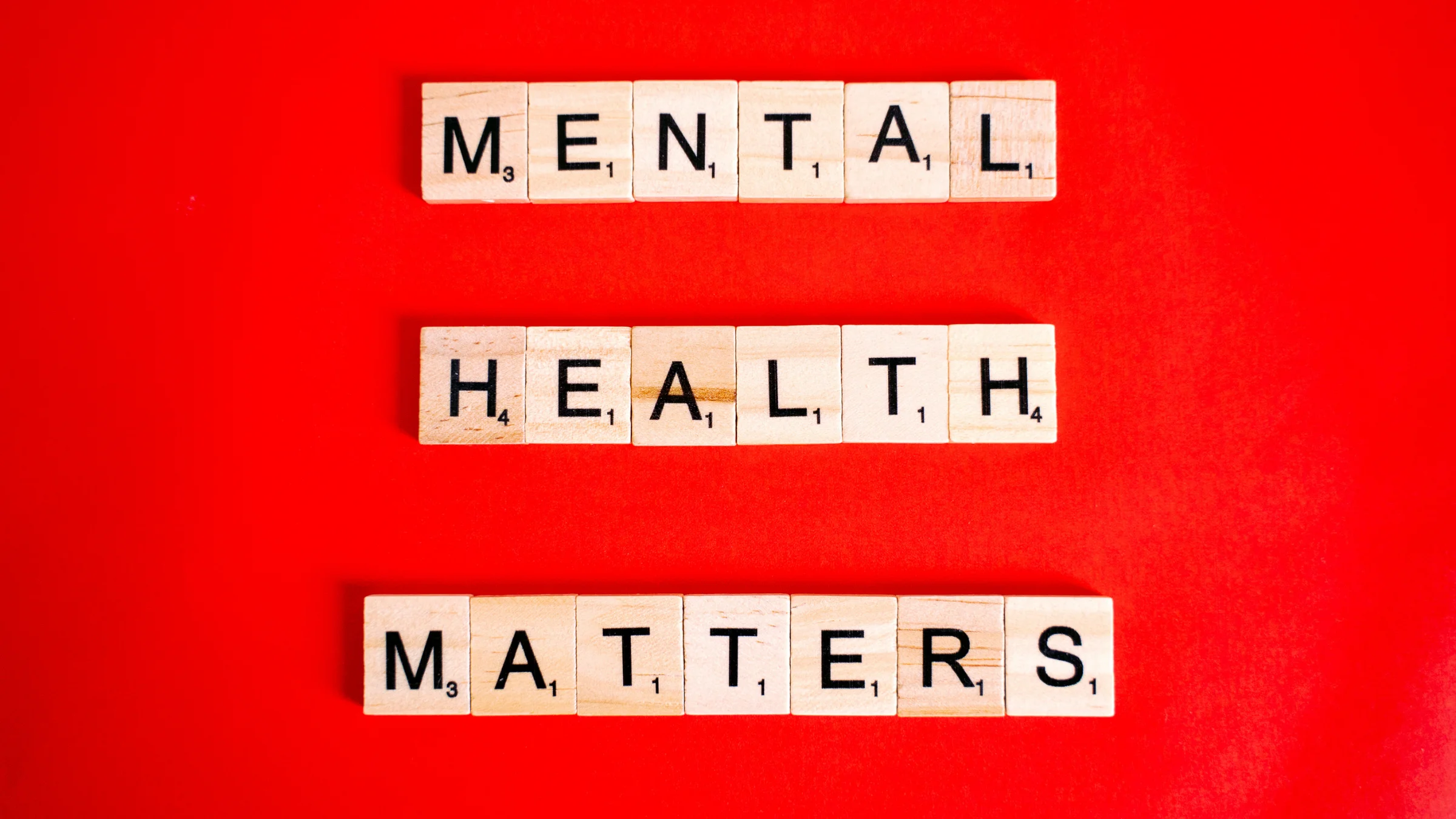 Mental Health Matters in wooden scrabble letters on a red background